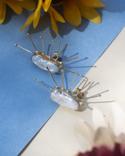 Luxurious pearl accent spiky statement studs for bold style.