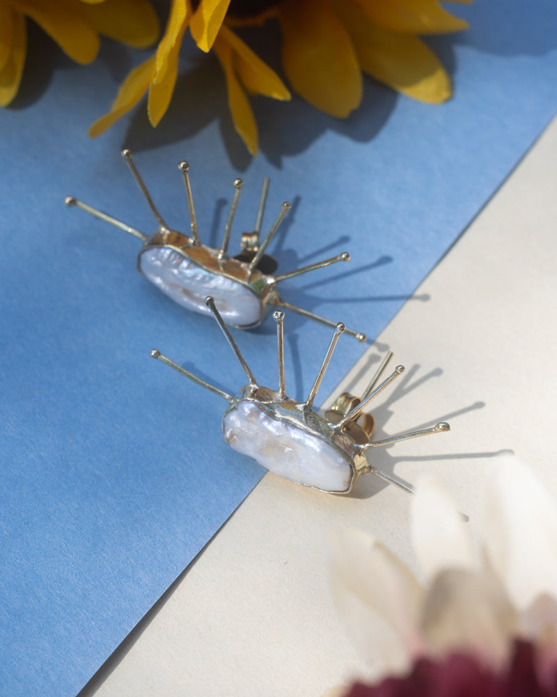 Luxurious pearl accent spiky statement studs for bold style.