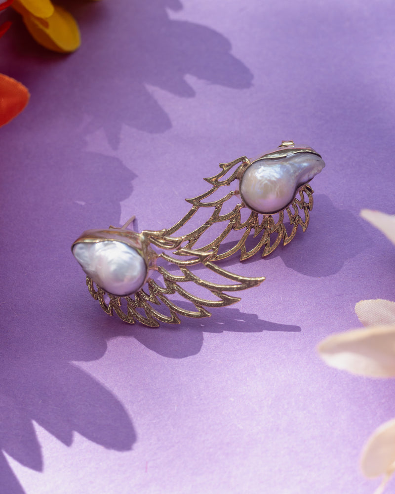 Elegant angel wings statement studs with pearls, crafted for grace.