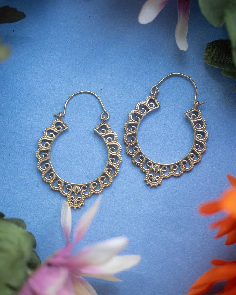 Gold-plated round gypsy hoops with tribal flower motif.