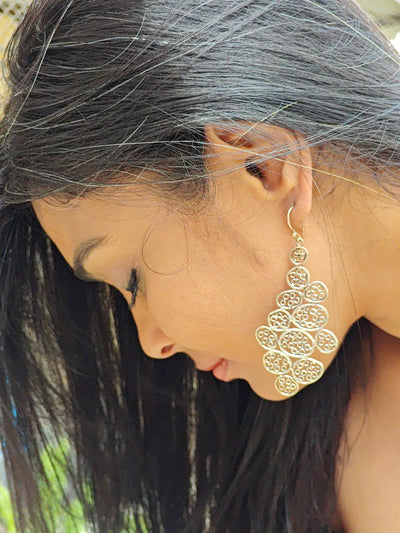 Woman wearing handcrafted designer silver statement earrings from the Modern Boho Collection by Surbhie, showcasing elegant filigree pattern and artistic detailing.