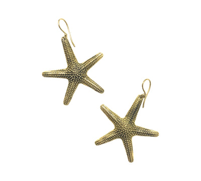 Close-up of gold starfish earrings on white background, highlighting handcrafted finish and beach-inspired charm.