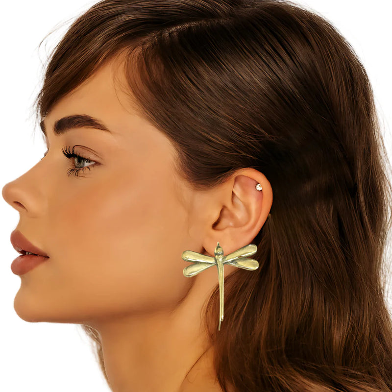 Woman wearing gold-plated dragonfly earrings, showcasing their delicate and statement-making nature-inspired look.