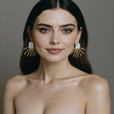 Woman wearing large, pearl statment earrings against a neutral background