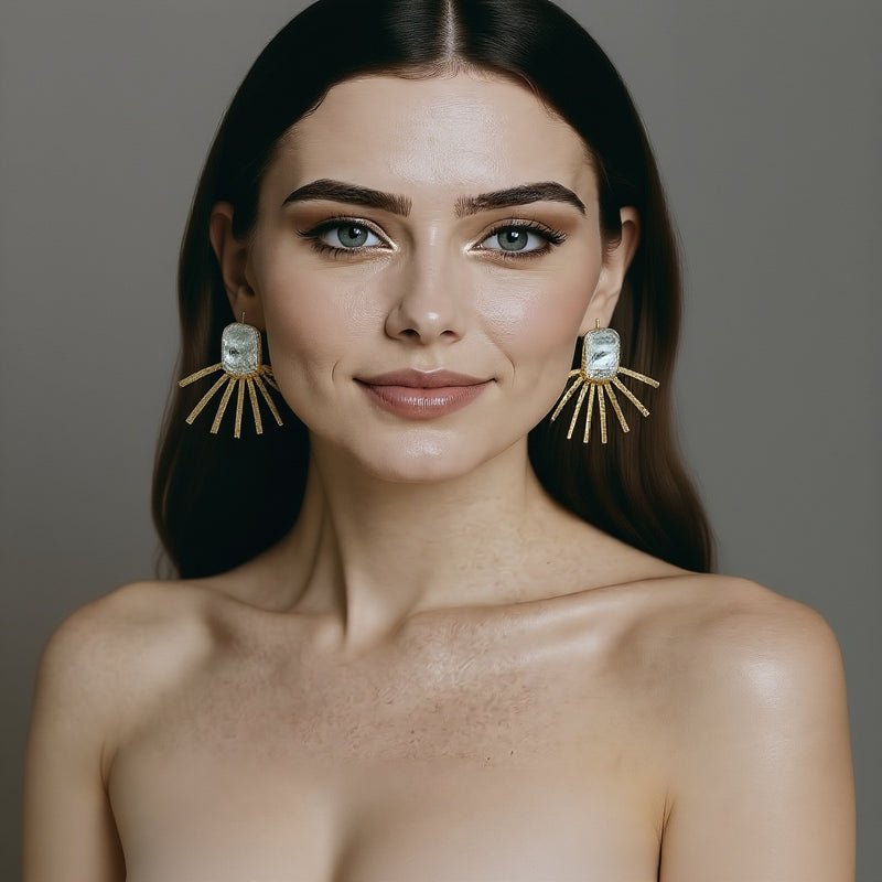 Woman wearing large, pearl statment earrings against a neutral background