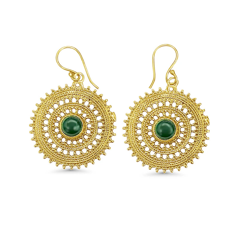 Gold round mandala earrings with green stone centerpiece displayed on white background, featuring intricate tribal-inspired geometric detailing.