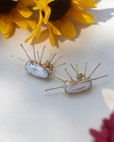 Handmade Salma Studs featuring natural baroque pearls with gold spike detailing, displayed with sunflower background for a radiant look.