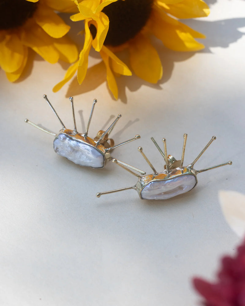 Handmade Salma Studs featuring natural baroque pearls with gold spike detailing, displayed with sunflower background for a radiant look.