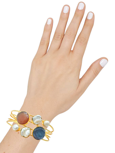 Nature-inspired gold cuff with brown & blue quartz stones, adjustable design.