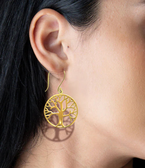Model wearing gold tree of life earrings, elegant and timeless accessory.