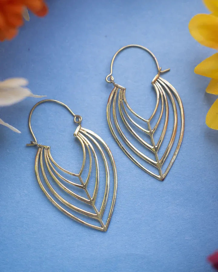 Bohemian minimalist gold tone leaf earrings displayed on blue floral background.