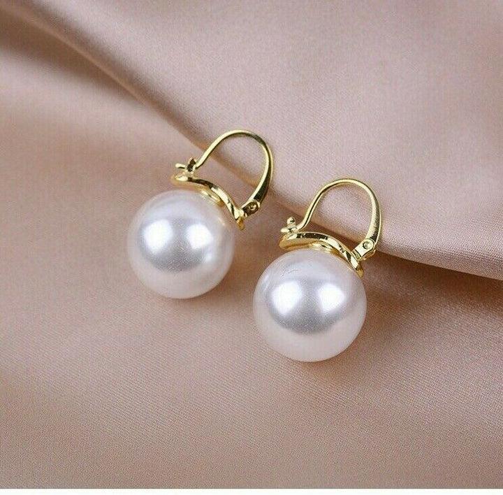 Close-up of Pearl & Gold Drop Hoop Earrings showing polished finish and clasp design.