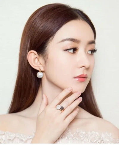 Elegant portrait showcasing Gold Drop Pearl Hoop Earrings for women.