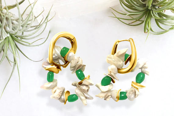 Gold-plated emerald pearl cluster hoop earrings displayed with natural elements, chic handcrafted look.