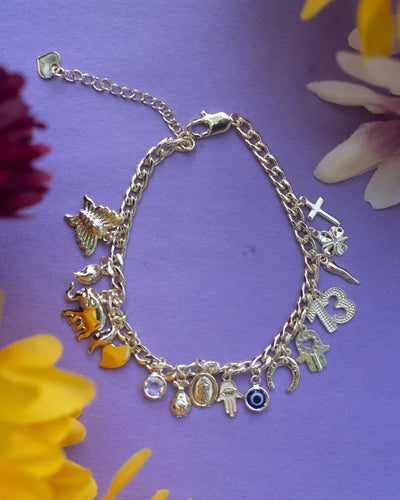 Flatlay of gold finish evil eye and charm bracelet with elephant, heart, and butterfly on purple background.