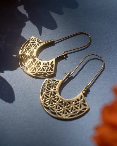 Flower Of Life Gold Metal Drop Earrings glowing under soft studio lighting.