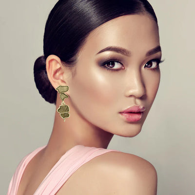 Model wearing gold plated asymmetrical drop stud earrings, minimal yet elegant accessory.