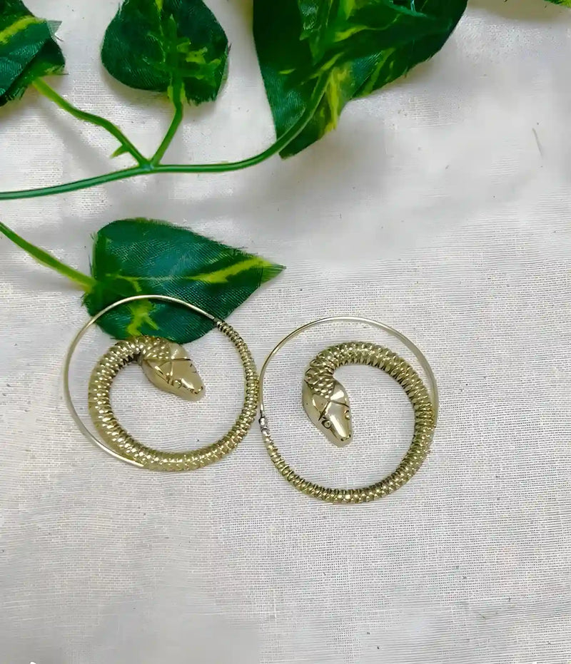 Gold snake threader earrings displayed on fabric background, minimalist design.