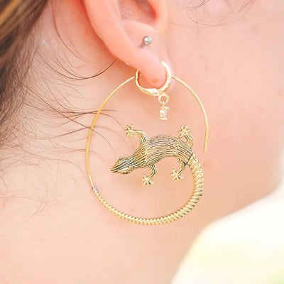 Model wearing golden lizard hoop earrings, unique animal-inspired fashion jewelry.