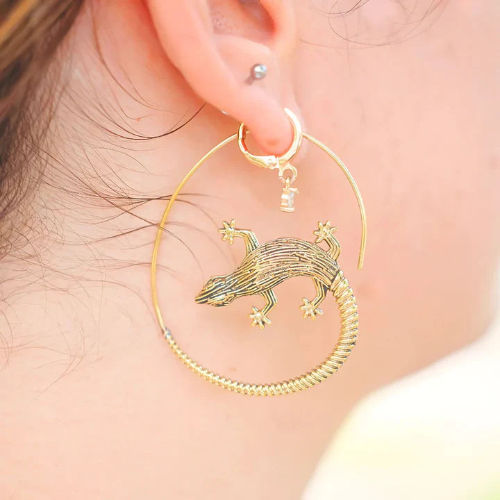Model wearing golden lizard hoop earrings, unique animal-inspired fashion jewelry.