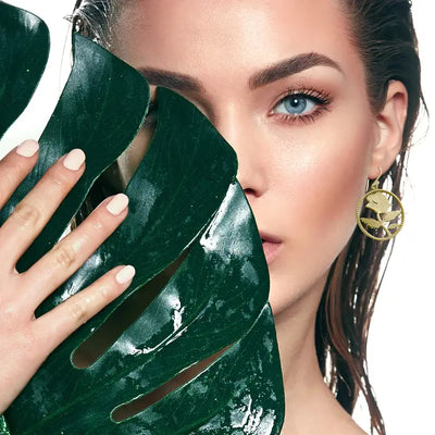 Editorial shot of model wearing golden rose earrings, elegant nature-themed statement accessory.