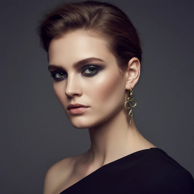 Model wearing golden serpent drop earrings, elegant and powerful fashion accessory.