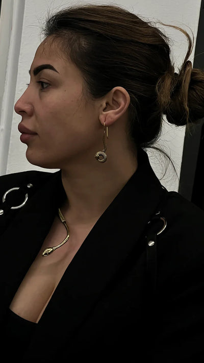 Side profile of model wearing gold snake collar necklace, sleek and modern accessory.