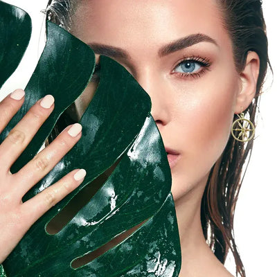 Editorial image of model wearing boho wheel spoke earrings, stylish gold statement earrings.