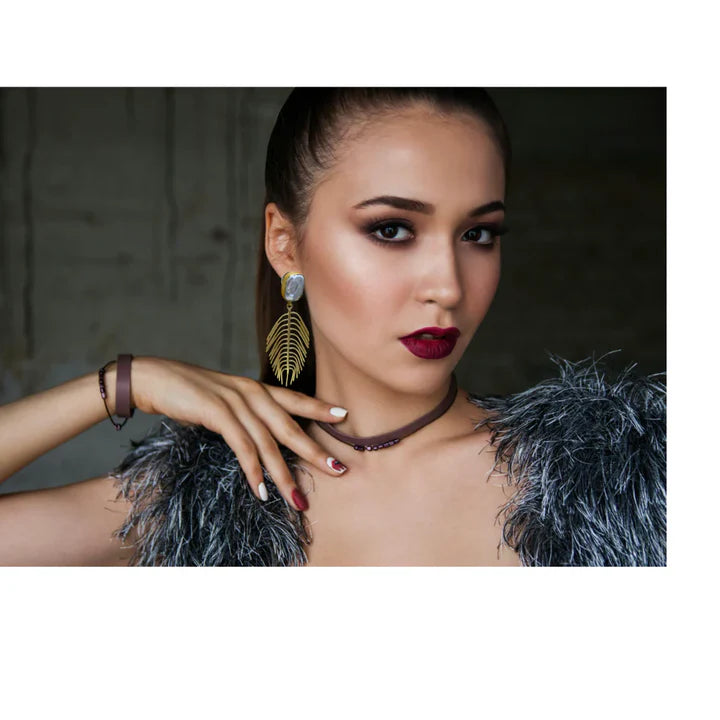 Model wearing iridescent pearl leaf drop earrings, bold and glamorous accessory.