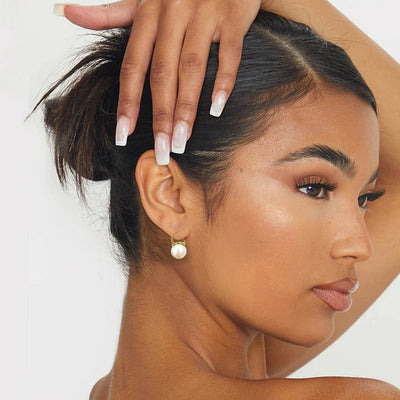 Model styled with Pearl Drop Gold Huggie Hoop Earrings for everyday elegance.