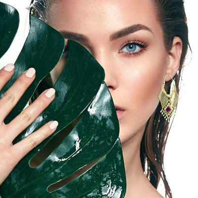 Model styling geometric beaded purple labradorite stone drop earrings for elegant evening look.