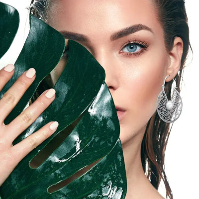 Model wearing sterling silver mandala flower white cat eye stone hoop earrings with elegant shine.