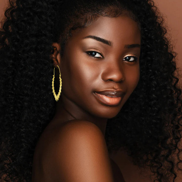 Model wearing Tribal Leaves Drop Gold Plated Hoop Earrings for a statement ethnic look.