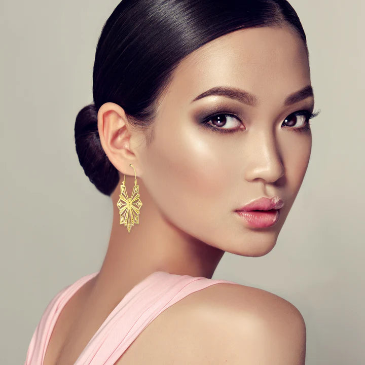 Model wearing Vintage Geometric Gold Metal Hollow Flower Drop Earrings for a chic statement look.