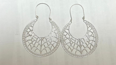 Pair of silver hoop earrings on a light gray background