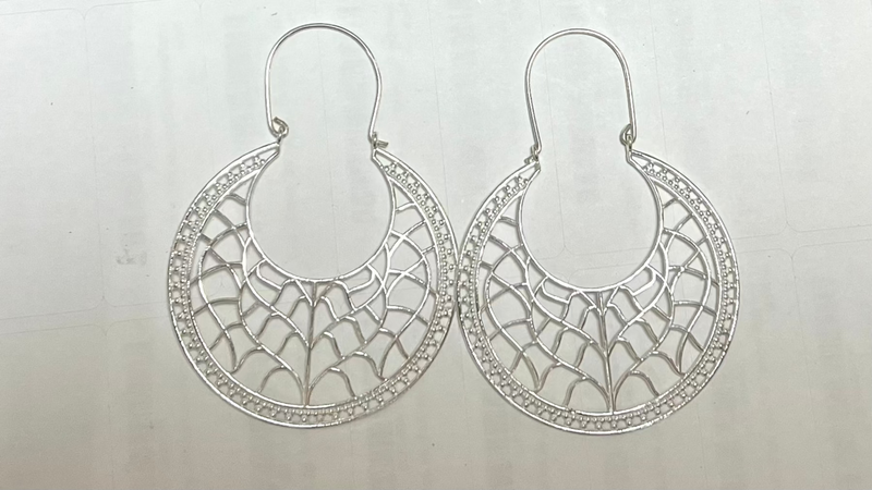 Pair of silver hoop earrings on a light gray background