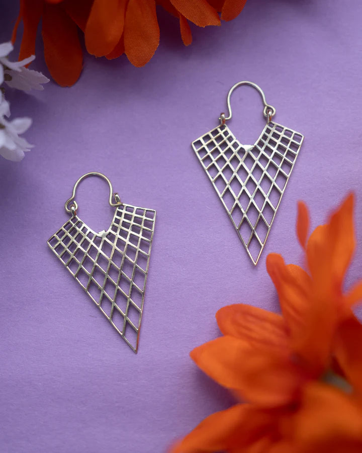 Pair of gold net drop hoops earrings displayed on purple background with floral decor.