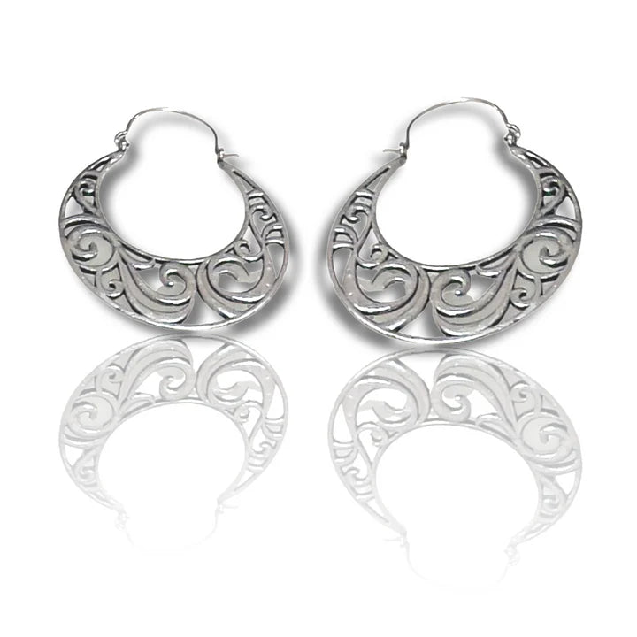 Pair of silver vintage curvy boho hoop earrings displayed on reflective surface.