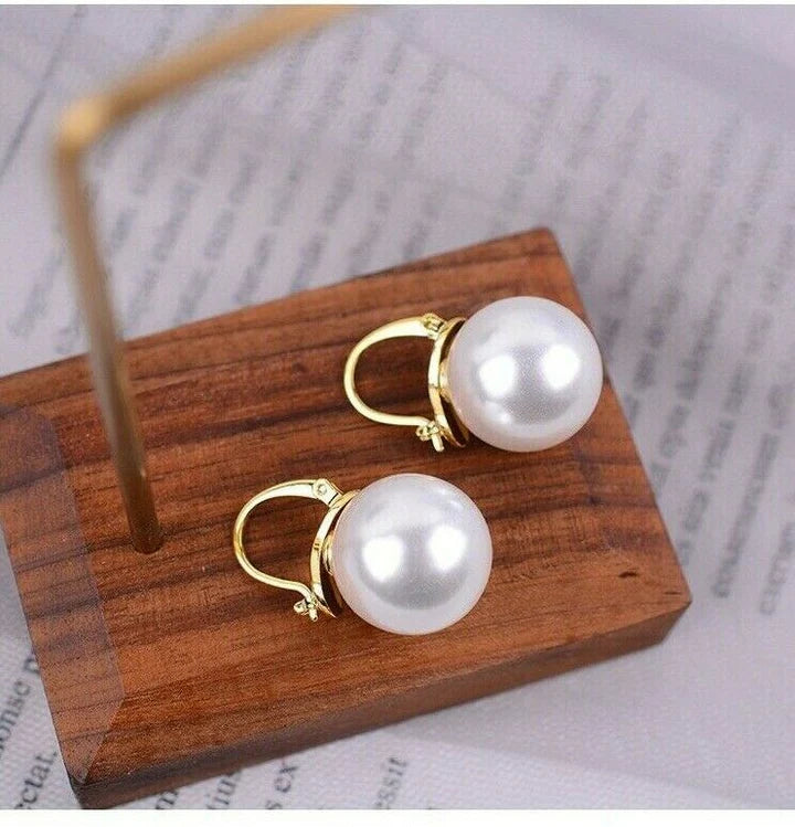Pearl and Gold Hoop Earrings displayed on wooden surface.