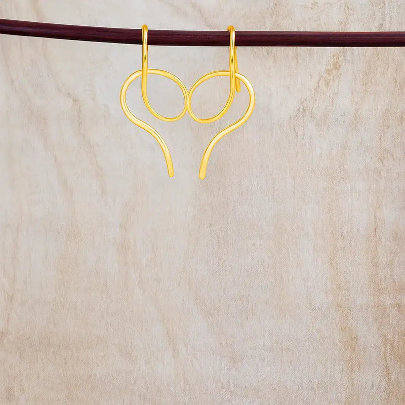 Front view of gold serpentine glow skinny snake drop earrings with curved loop design.