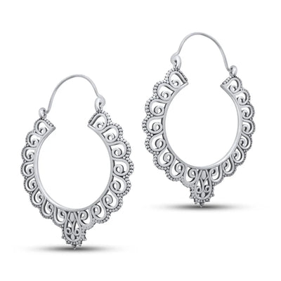 Lifestyle image of silver floral chunky hoop earrings placed among orange flowers.