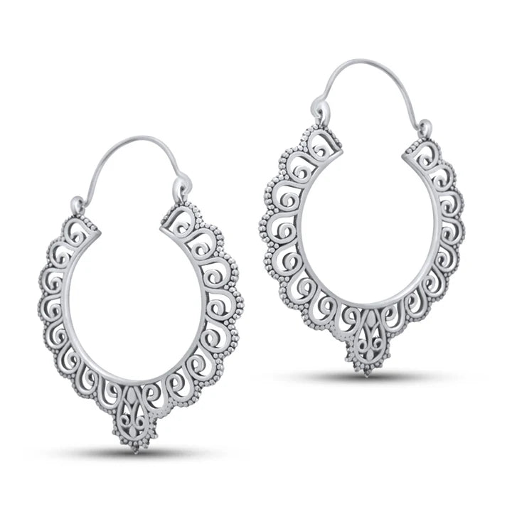 Lifestyle image of silver floral chunky hoop earrings placed among orange flowers.