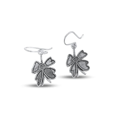Front view of vintage open flower dangle and drop silver plated earrings with intricate detailing. 